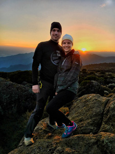 Hikers pose for photo at sunset on mountain top